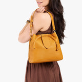 Sunshine Large | Model holding symmetrical leather bag with leather drawstring closure and adjustable shoulder strap