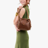 Asheville Small | Model holding symmetrical leather bag with leather drawstring closure and adjustable shoulder strap
