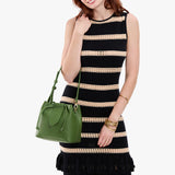 Cactus Small | Model holding symmetrical leather bag with leather drawstring closure and adjustable shoulder strap