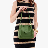 Cactus Small | Model holding symmetrical leather bag with leather drawstring closure and adjustable shoulder strap