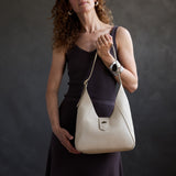 Jasmine | Model carrying structured hobo shoulder bag with floral patterned embossed leather, adjustable strap and magnetic closure