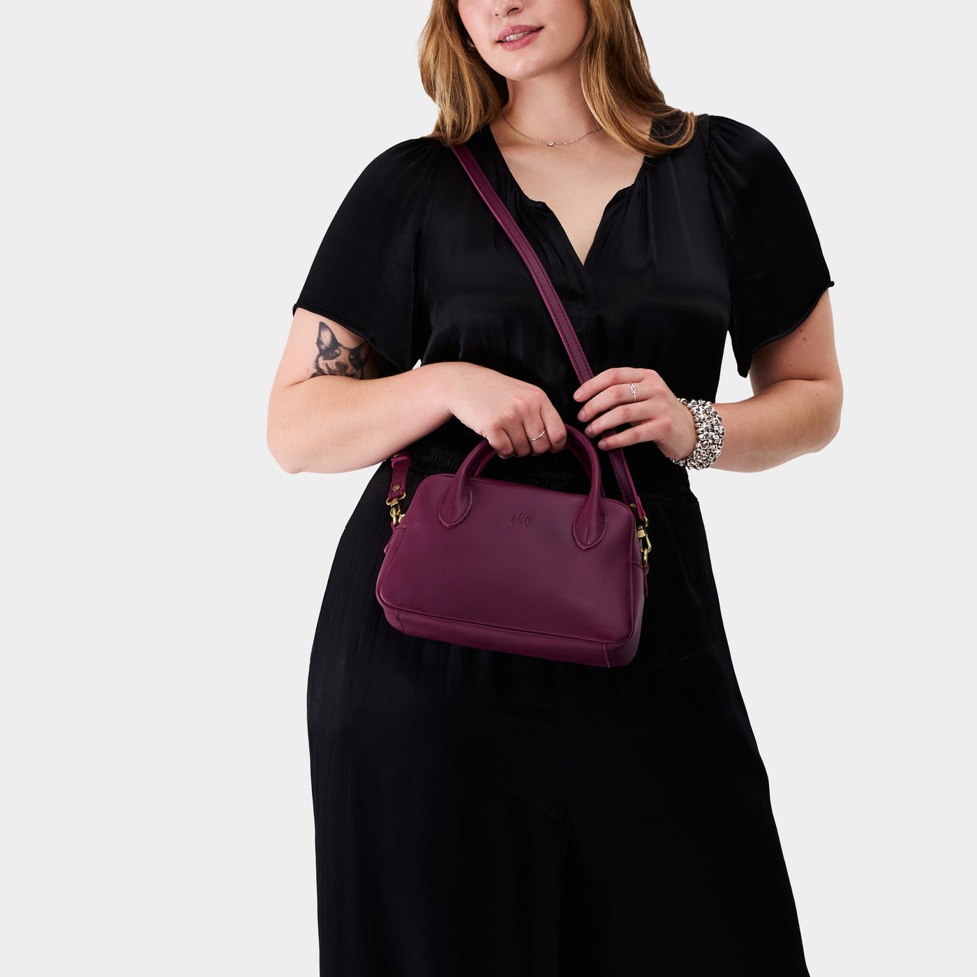 Lollipop*Large | A large bowler styled bag with a crossbody strap being worn by a model wearing a black dress