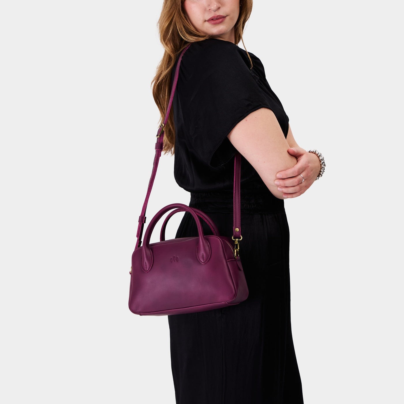 Lollipop*Large | A large bowler styled bag with a crossbody strap being worn by a model wearing a black dress