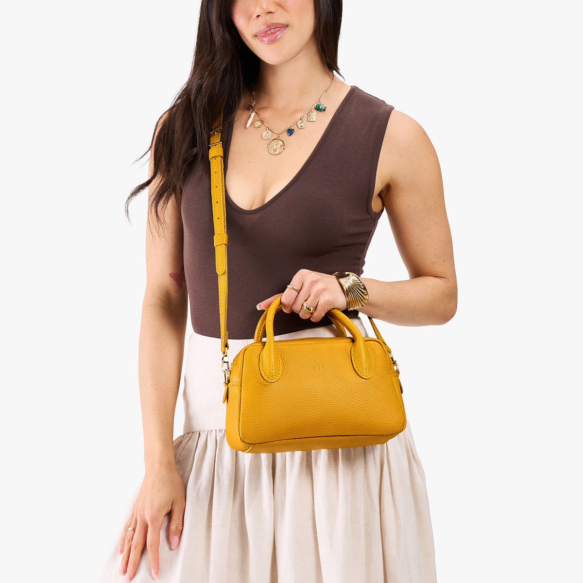 Sunshine*Large | A large bowler styled bag with a crossbody strap being worn by a model in a neutral outfit