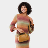Mango Small | A bowler styled bag with a crossbody strap being worn by a model wearing a multi-colored dress