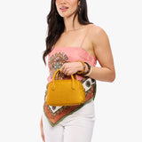 Sunshine Small | A bowler styled bag being held by a model