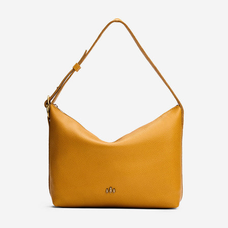 Sunshine*Small | Slouchy Shoulder Bag that has a zipper opening and three metal tree emblems on a white background