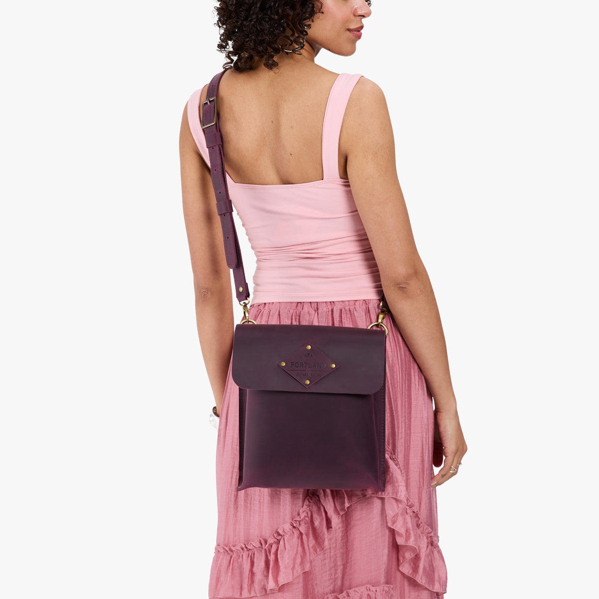 Larkspur | Model carrying slim satchel bag with crossbody strap and flap with magnet snap closure