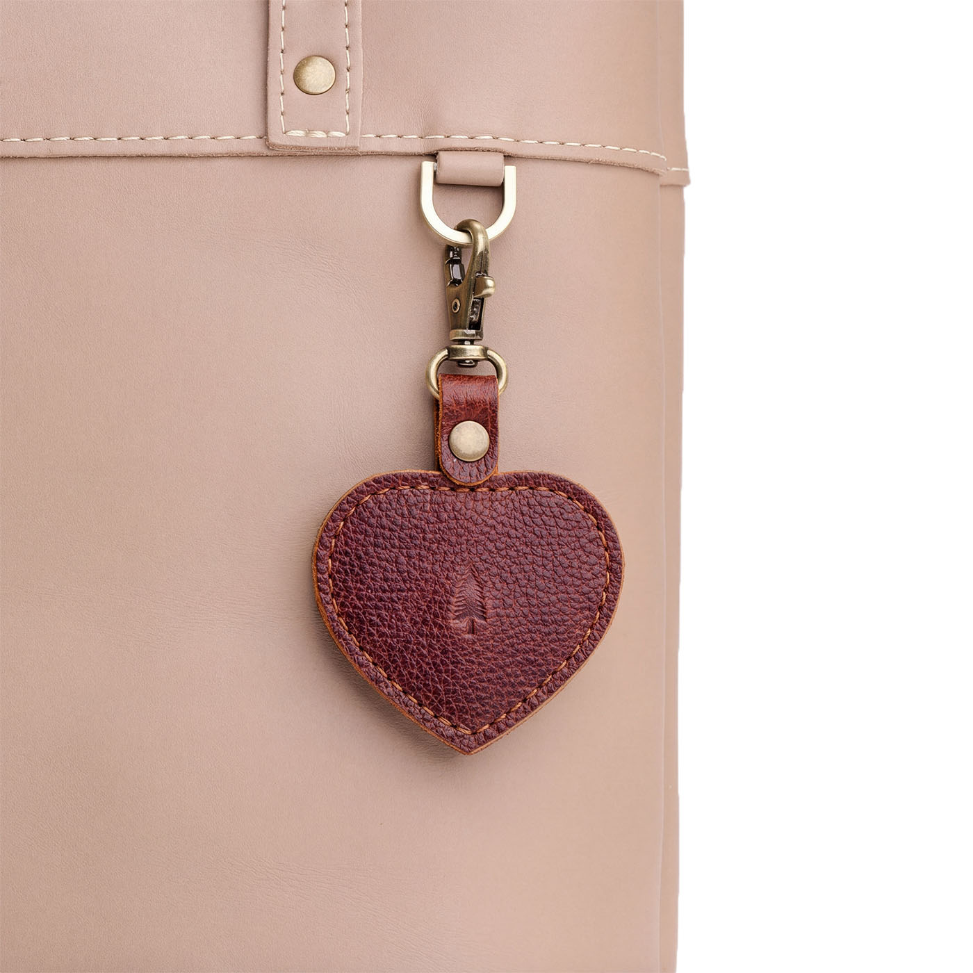 Nutmeg | Heart-shaped airtag holder keychain with a swivel lobster clasp on bag