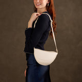 Pebbled Bone Small | Model wearing half circle shaped sling bag