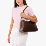 Chocolate Brown Large | Model holding a bean shaped shoulder bag with a zipper closure