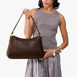Coldbrew Large | Model holding a bean shaped shoulder bag with a zipper closure