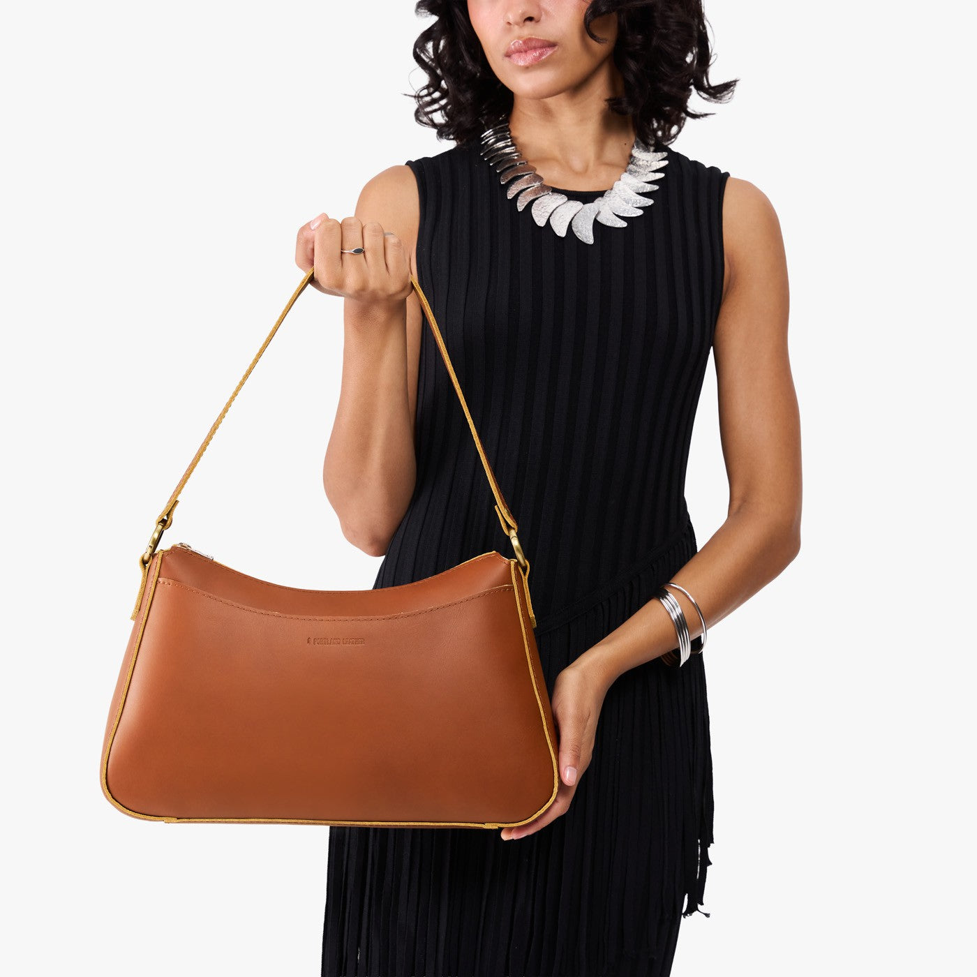 Honey*Large | Model holding a bean shaped shoulder bag with a zipper closure