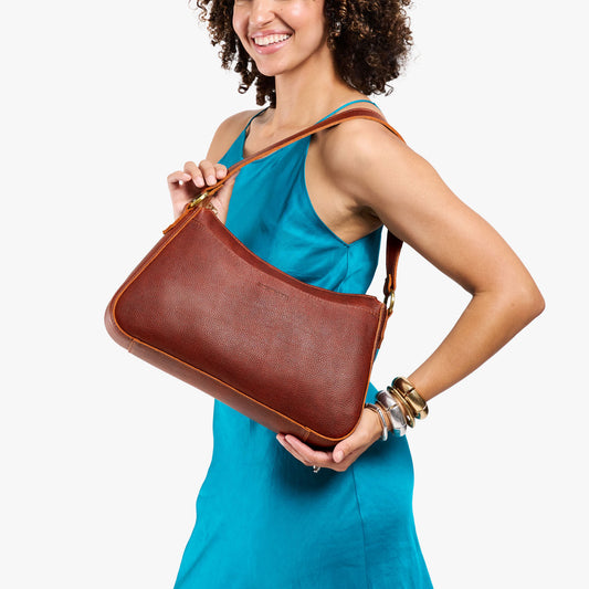 Nutmeg*Large | Model holding a bean shaped shoulder bag with a zipper closure