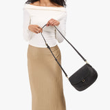 Full Moon Large | Model wearing a leather Crossbody with a flap and magnetic closure