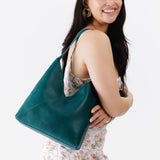 Sea Glass Large | Model wearing petite shoulder bag with adjustable strap and magnetic snap closure