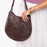Sepia Large | Model holding round leather purse with adjustable shoulder strap
