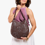 Sepia Large | Model holding round leather purse with adjustable shoulder strap