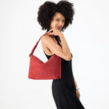 Cinnabar Large | Model holding a Slouchy Shoulder Bag that has a zipper opening and three metal tree emblems