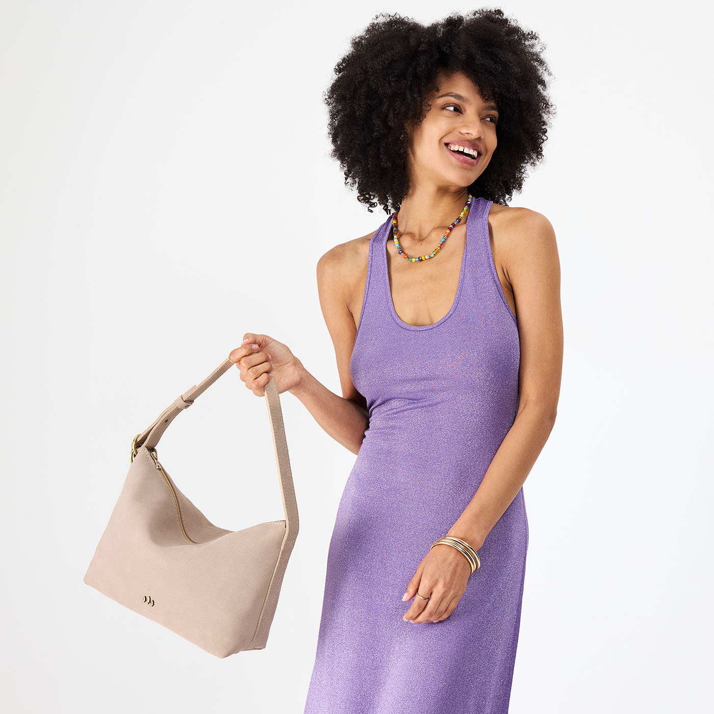 Taupe*Large | Model holding a Slouchy Shoulder Bag that has a zipper opening and three metal tree emblems