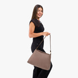 Sparrow Large | Model holding a triangular shoulder bag with antiqued brass finished 