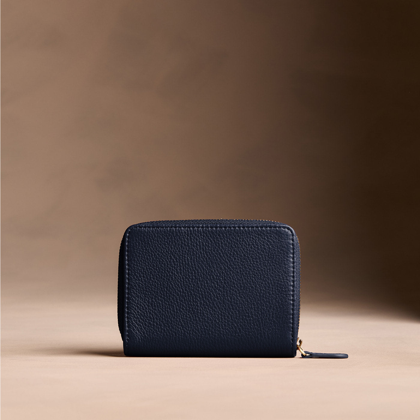 Anchor Blue | Wallet with card and storage pockets on a light brown background - back view
