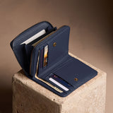 Anchor Blue | Open wallet with card and storage pockets on a light brown background