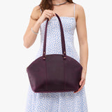 Larkspur Large | Model holding a half circle crossbody bag with handles and removable crossbody strap 