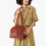 Nutmeg Large | Model holding a half circle crossbody bag with handles and removable crossbody strap 
