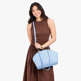 Skyway Large | Model holding a half circle crossbody bag with handles and removable crossbody strap