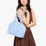 Skyway Large | Model holding a half circle crossbody bag with handles and removable crossbody strap
