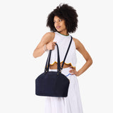 Velvet Blue Large | Model holding a half circle crossbody bag with handles and removable crossbody strap