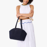Velvet Blue Large | Model holding a half circle crossbody bag with handles and removable crossbody strap