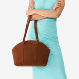 Wildwood Large | Model holding a half circle crossbody bag with handles and removable crossbody strap