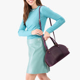 Larkspur Small | Model holding a half circle crossbody bag with handles and removable crossbody strap 
