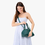 Sea Glass Small | Model holding a half circle crossbody bag with handles and removable crossbody strap