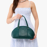 Sea Glass Small | Model holding a half circle crossbody bag with handles and removable crossbody strap