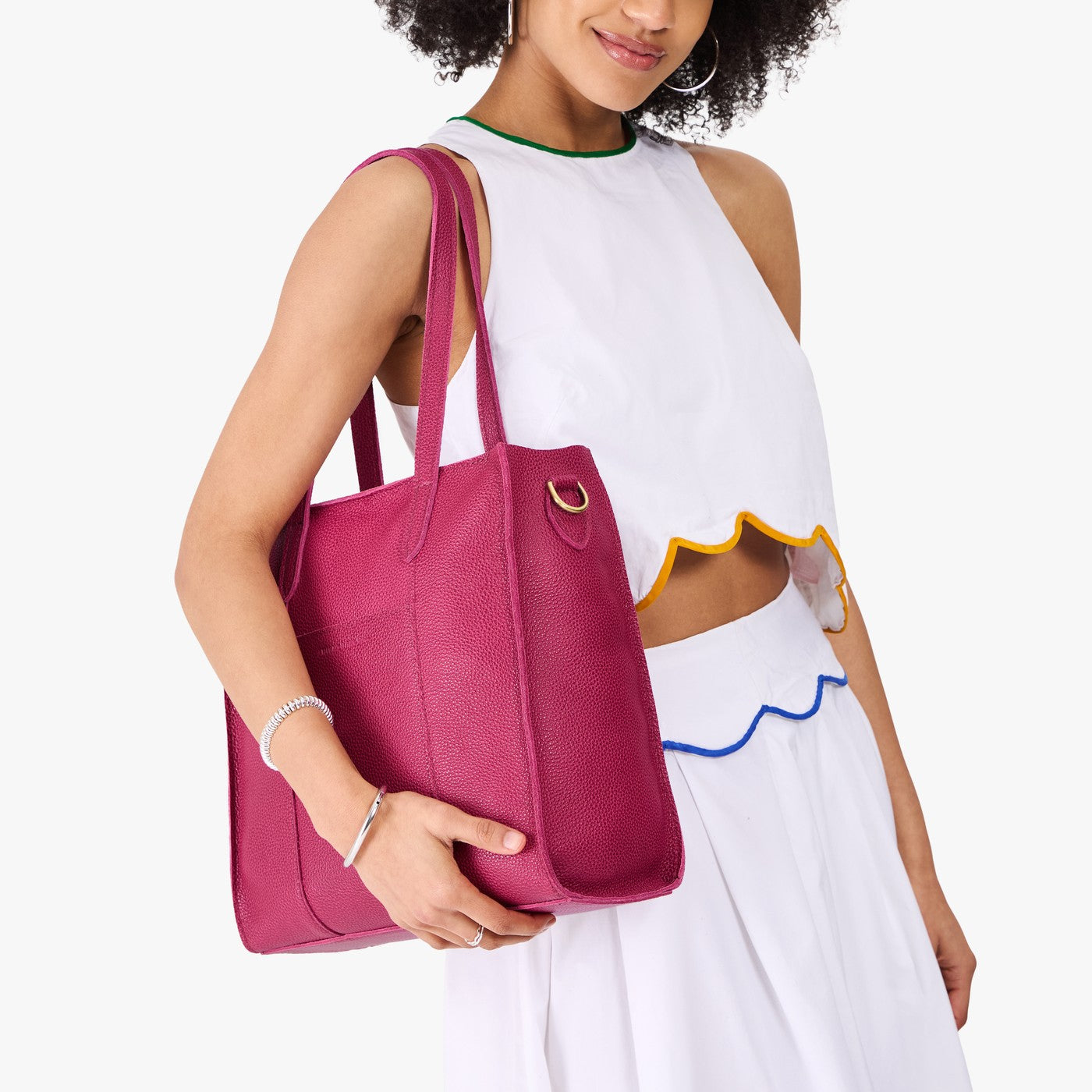 Cosmo*North/South| Model holding structured wide tote bag with overlapping panels and crossbody strap