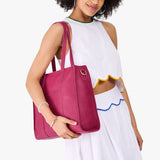 Cosmo North/South| Model holding structured wide tote bag with overlapping panels and crossbody strap