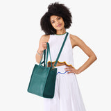 Sea Glass North/South | Model wearing structured large tote bag with overlapping panels and crossbody strap