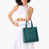Sea Glass North/South | Model wearing structured large tote bag with overlapping panels and crossbody strap