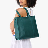 Sea Glass North/South | Model wearing structured large tote bag with overlapping panels and crossbody strap