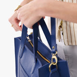 Molino Blue Zipper | Model holding structured mid-size tote bag with overlapping panels and crossbody strap
