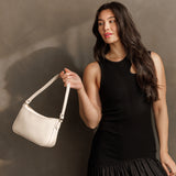Bone | Model holding petite bean shaped shoulder bag with a zipper closure