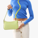 Shadow Lime | Model carrying petite bean shaped shoulder bag with a zipper closure