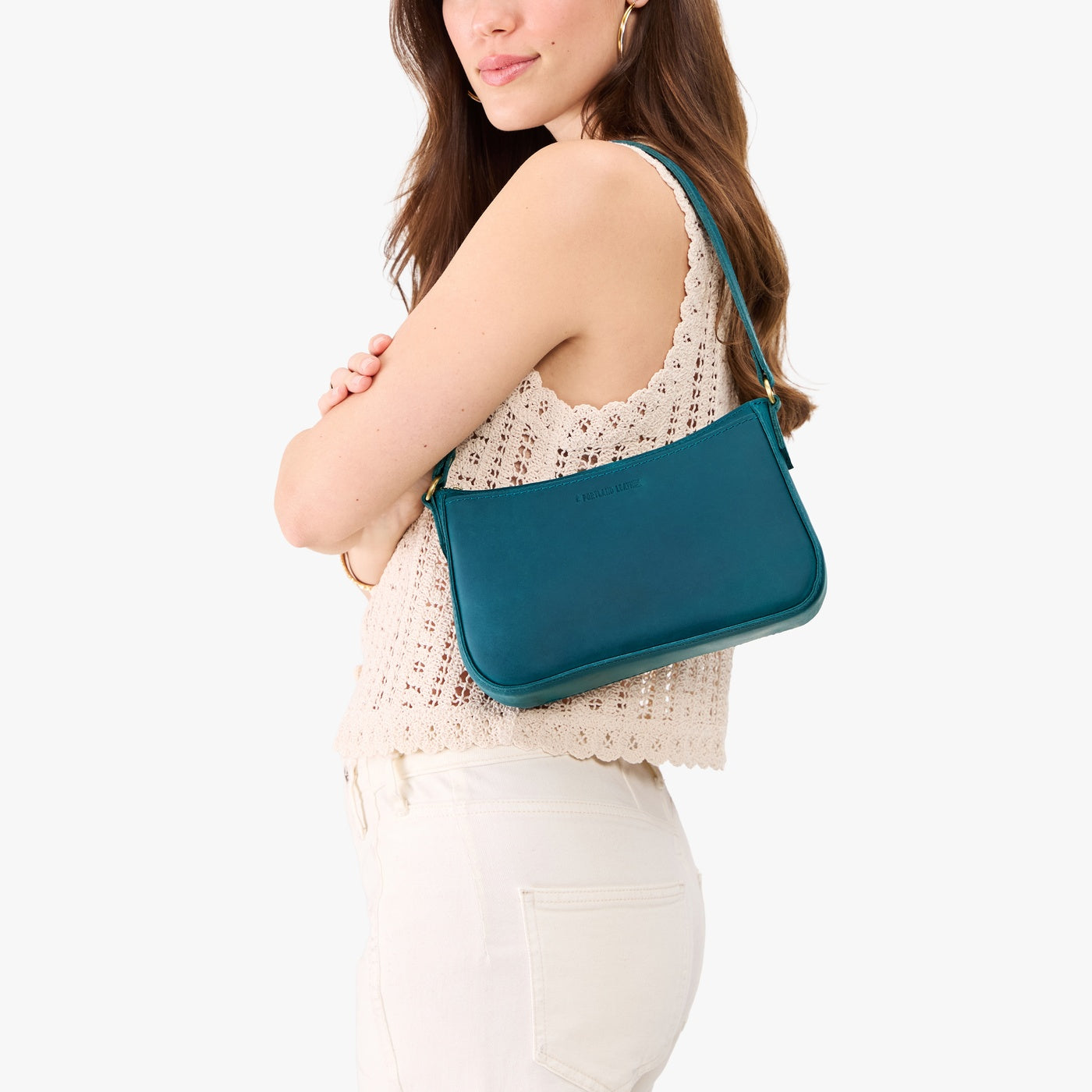 Westward Blue | Model carrying petite bean shaped shoulder bag with a zipper closure