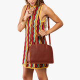 Nutmeg Medium | Model carrying leather tote bag with handles, adjustable crossbody strap, and two back pockets