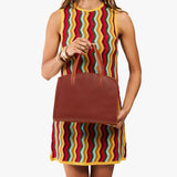 Nutmeg Medium | Model carrying leather tote bag with handles, adjustable crossbody strap, and two back pockets