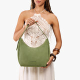 Laurel Medium | Model holding u-shaped, flat-bottomed leather shoulder bag with adjustable strap