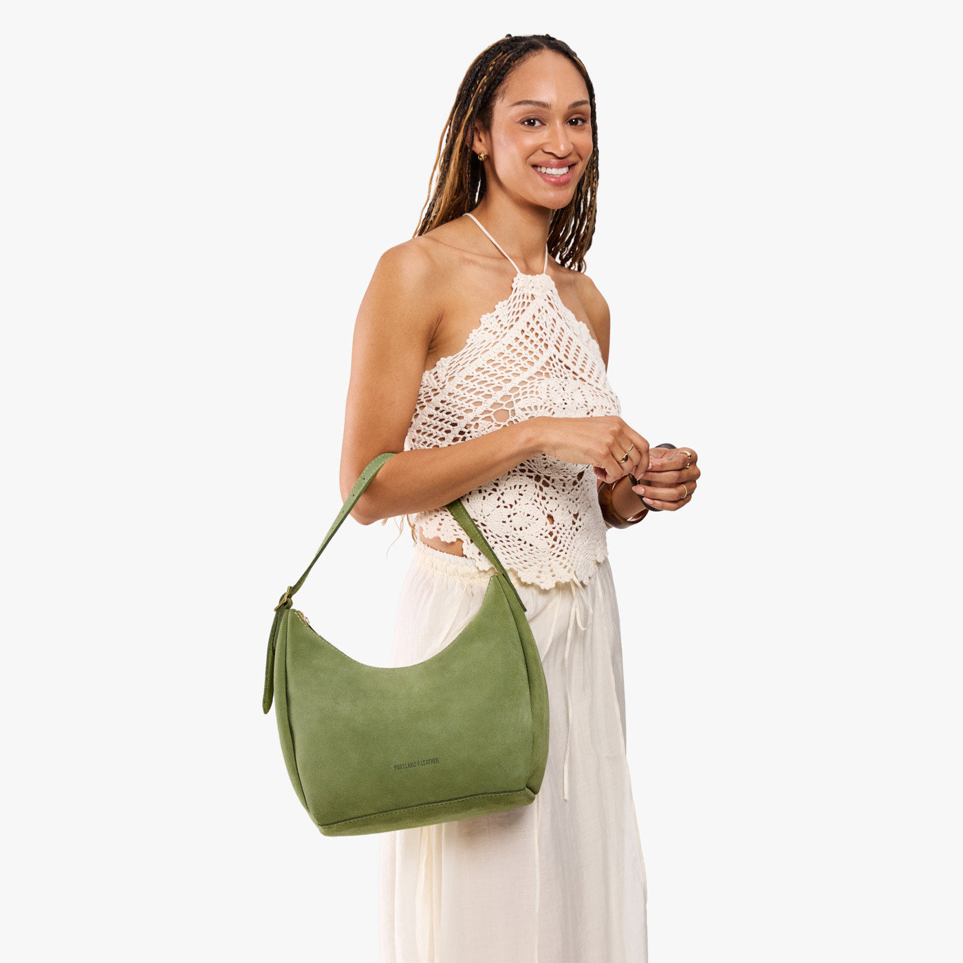 Laurel*Medium | Model holding u-shaped, flat-bottomed leather shoulder bag with adjustable strap